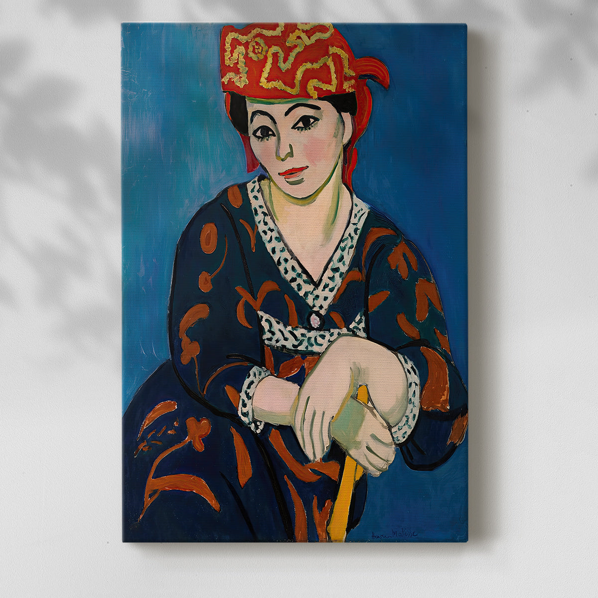 Canvas art print of a stylized face with bold textile pattern and warm tones with a soft shadow on a white background.