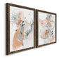 Angled view of a set of two walnut barnwood framed canvas prints featuring two abstract watercolor botanicals featuring loose blush gray and coral floral gestures.