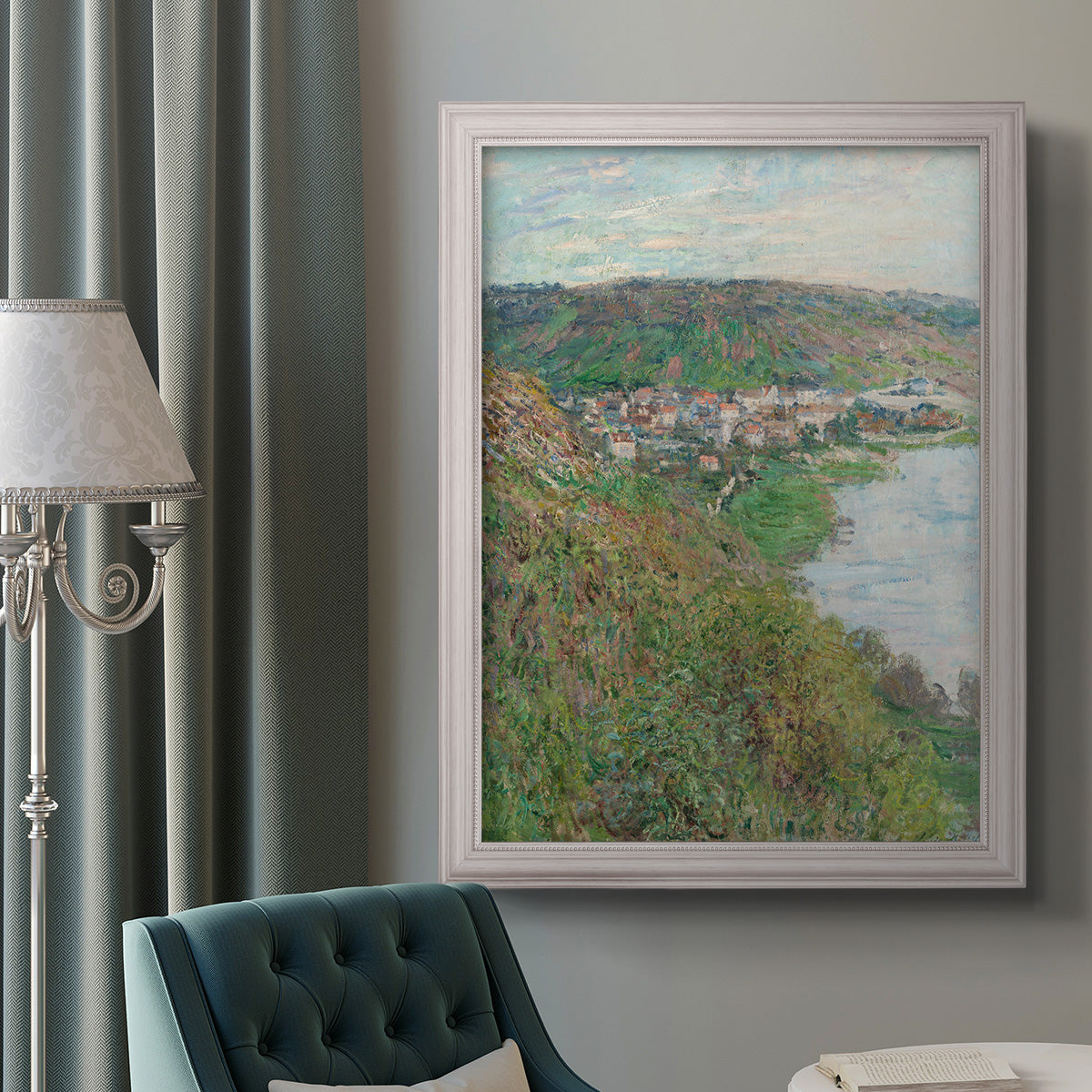Impressionist landscape view of Vétheuil by Claude Monet in an ornate weathered white frame displayed in a neutral interior setting.