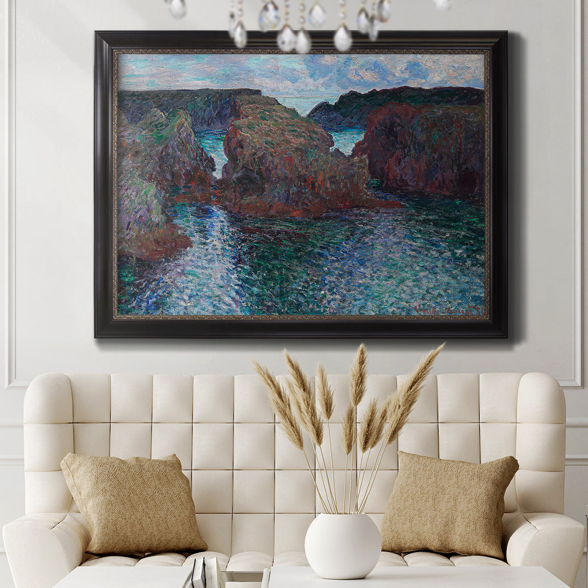Impressionist rocky seascape by Claude Monet in an ornate black frame with gilded inner detail displayed in a neutral-toned interior setting.