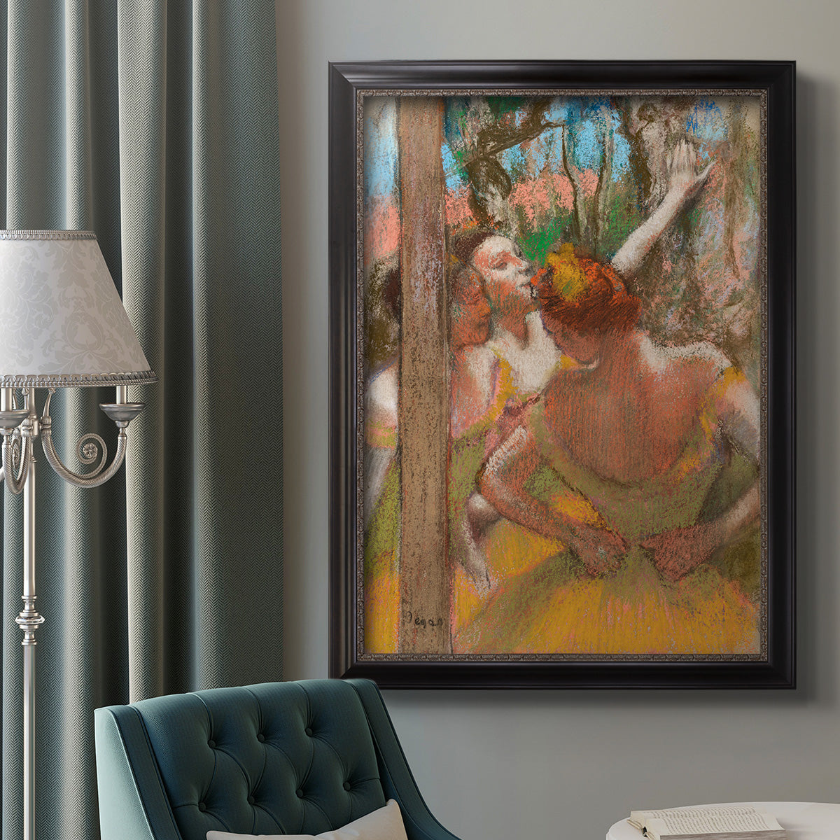 Impressionist ballet dancer composition by Edgar Degas in an ornate black frame with gilded inner detail displayed in a neutral interior setting.