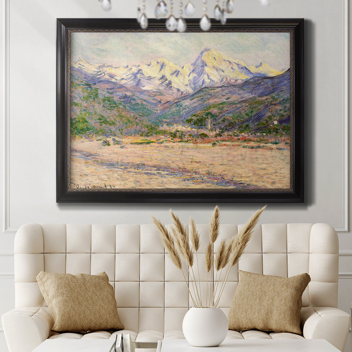 Impressionist valley landscape in southern France by Claude Monet in an ornate black frame with gilded inner detail displayed in a neutral-toned interior setting.