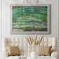 Impressionist garden scene with Japanese bridge and water lilies by Claude Monet in an ornate weathered white frame displayed in a neutral-toned interior setting.