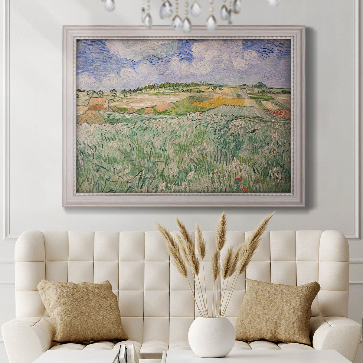 Impressionist countryside landscape near Auvers by Vincent van Gogh in an ornate weathered white frame displayed in a neutral-toned interior setting.