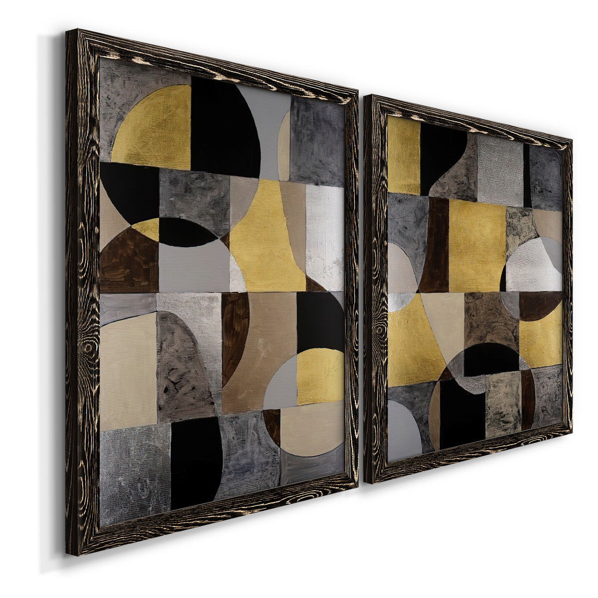 Angled view of a set of two black barnwood framed canvas prints featuring two structured modern abstracts featuring interlocking black gray cream and gold geometric sections.