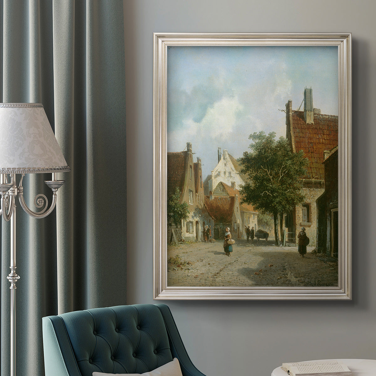 Rustic European street scene painting by Adriaan Eversen in an ornate champagne frame displayed in a neutral interior setting.