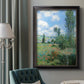 Impressionist pastoral landscape with poppy fields by Claude Monet in an ornate black frame with gilded inner detail displayed in a neutral interior setting.