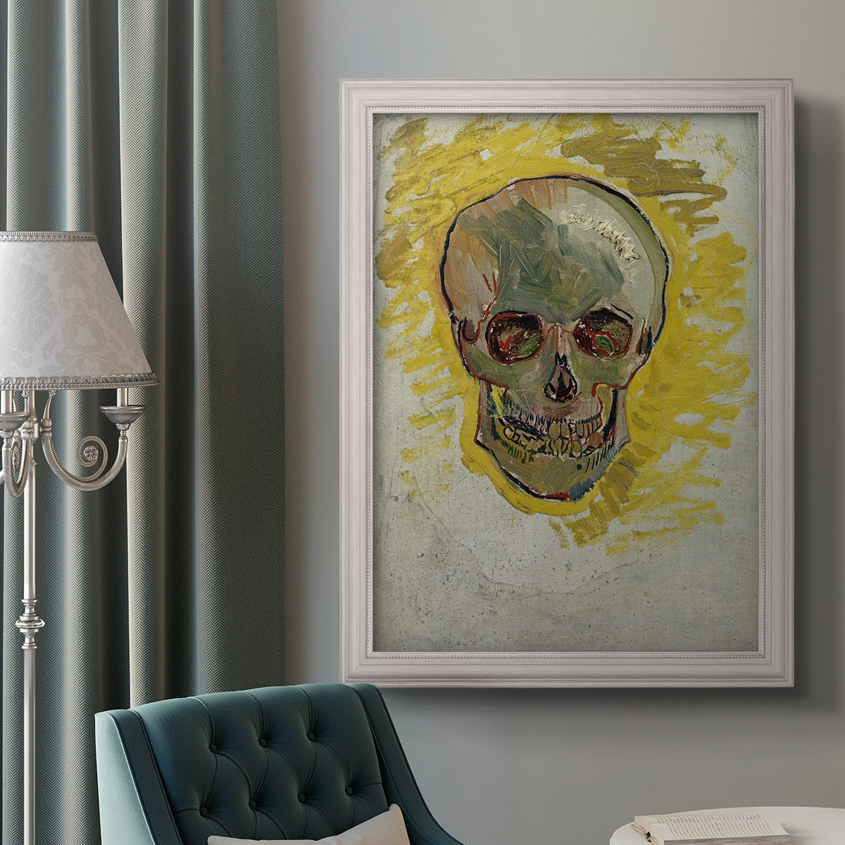 Expressive skull study painting by Vincent van Gogh in an ornate weathered white frame displayed in a neutral interior setting.