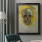 Expressive skull study painting by Vincent van Gogh in an ornate black frame with gilded inner detail displayed in a neutral interior setting.