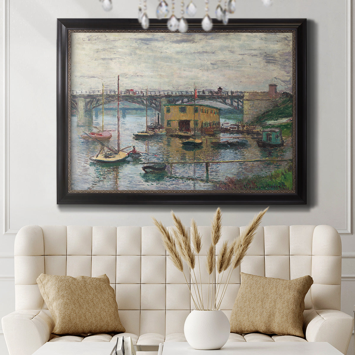 Impressionist river bridge scene on an overcast day by Claude Monet in an ornate black frame with gilded inner detail displayed in a neutral-toned interior setting.