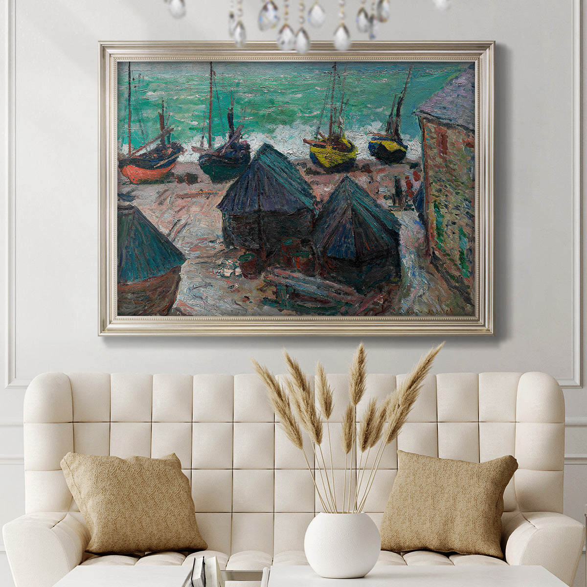 Impressionist coastal beach scene with boats by Claude Monet in an ornate champagne frame displayed in a neutral-toned interior setting.
