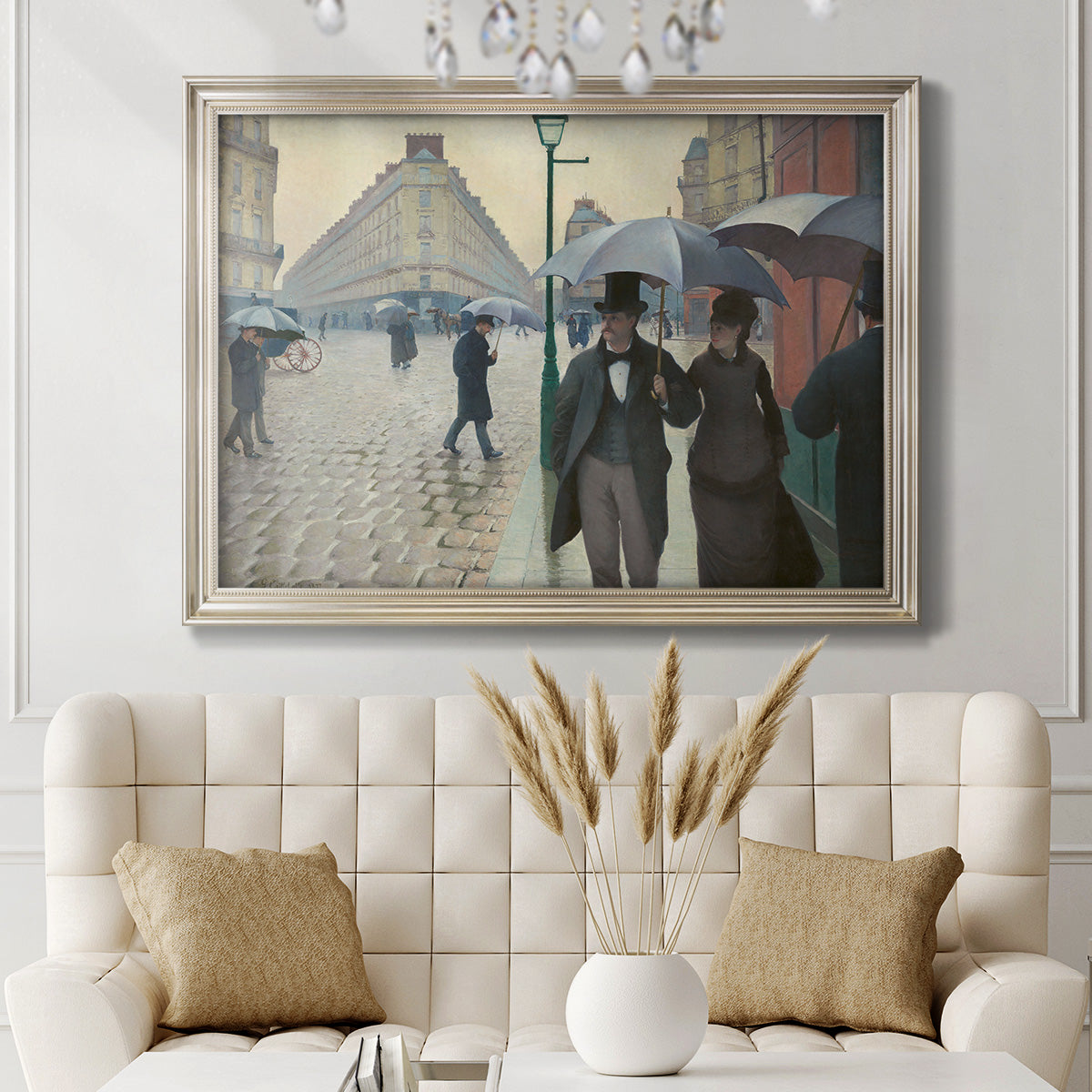 Impressionist urban street scene in the rain by Gustave Caillebotte in an ornate champagne frame displayed in a neutral-toned interior setting.