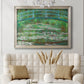 Impressionist garden scene with Japanese bridge and water lilies by Claude Monet in an ornate champagne frame displayed in a neutral-toned interior setting.