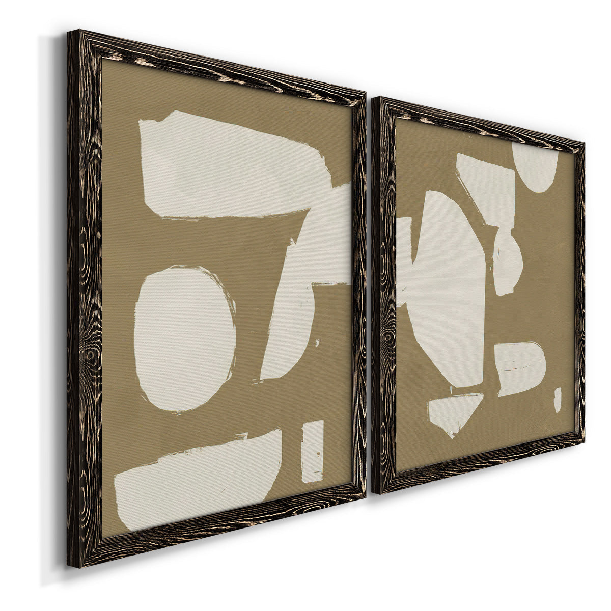 Angled view of a set of two black barnwood framed canvas prints featuring two bold minimalist shape abstracts featuring irregular white cutout-like shapes on taupe grounds.