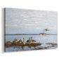 Canvas art print featuring birds standing and resting along shoreline with soft grass and water, displayed at an angle