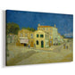 Canvas art print featuring an urban scene with bold-colored building along road, displayed at an angle