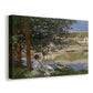 Canvas art print featuring a peaceful riverside scene with figures resting in grassy area by water, displayed at an angle