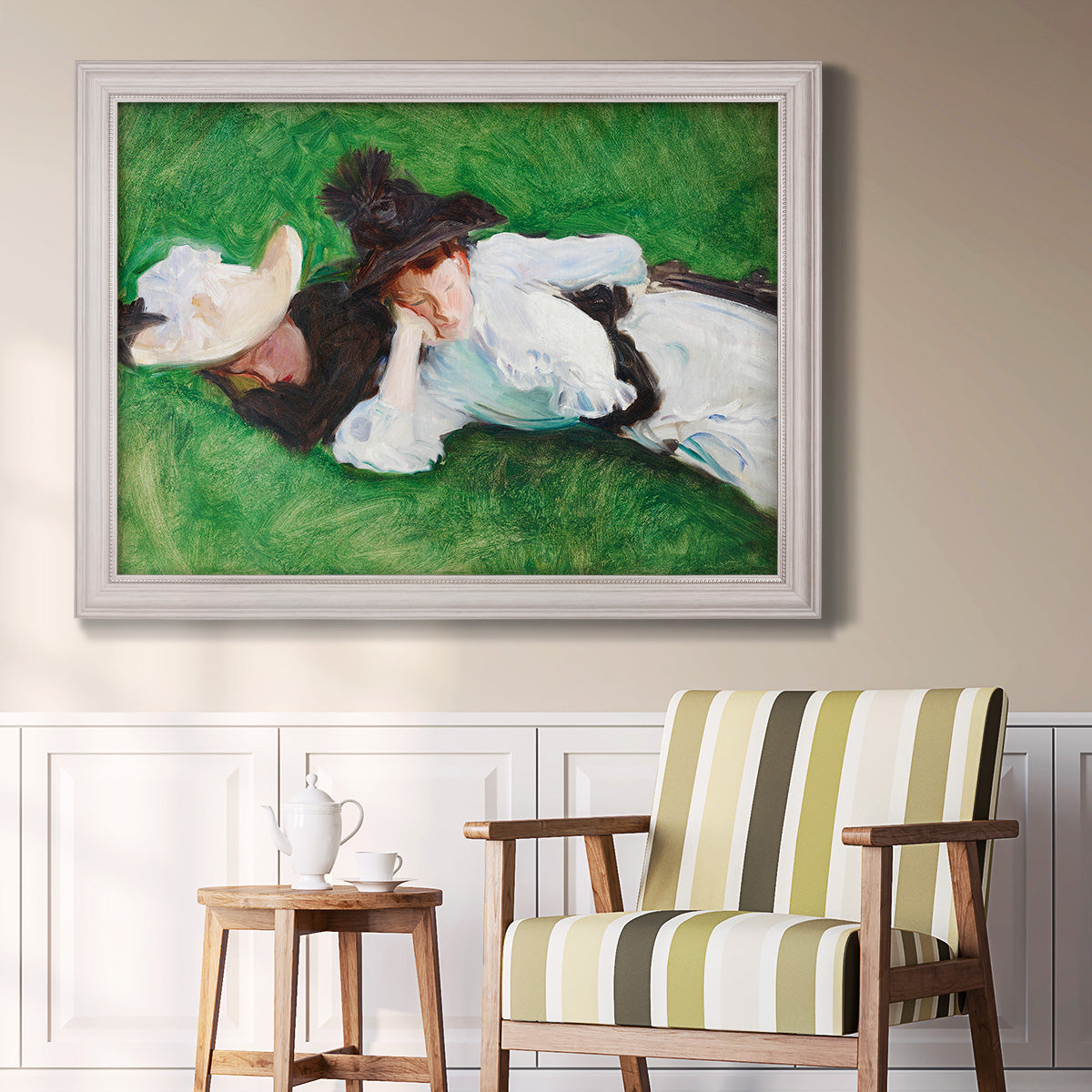 Impressionist outdoor portrait of two girls by John Singer Sargent in an ornate weathered white frame displayed in a light-toned interior setting.