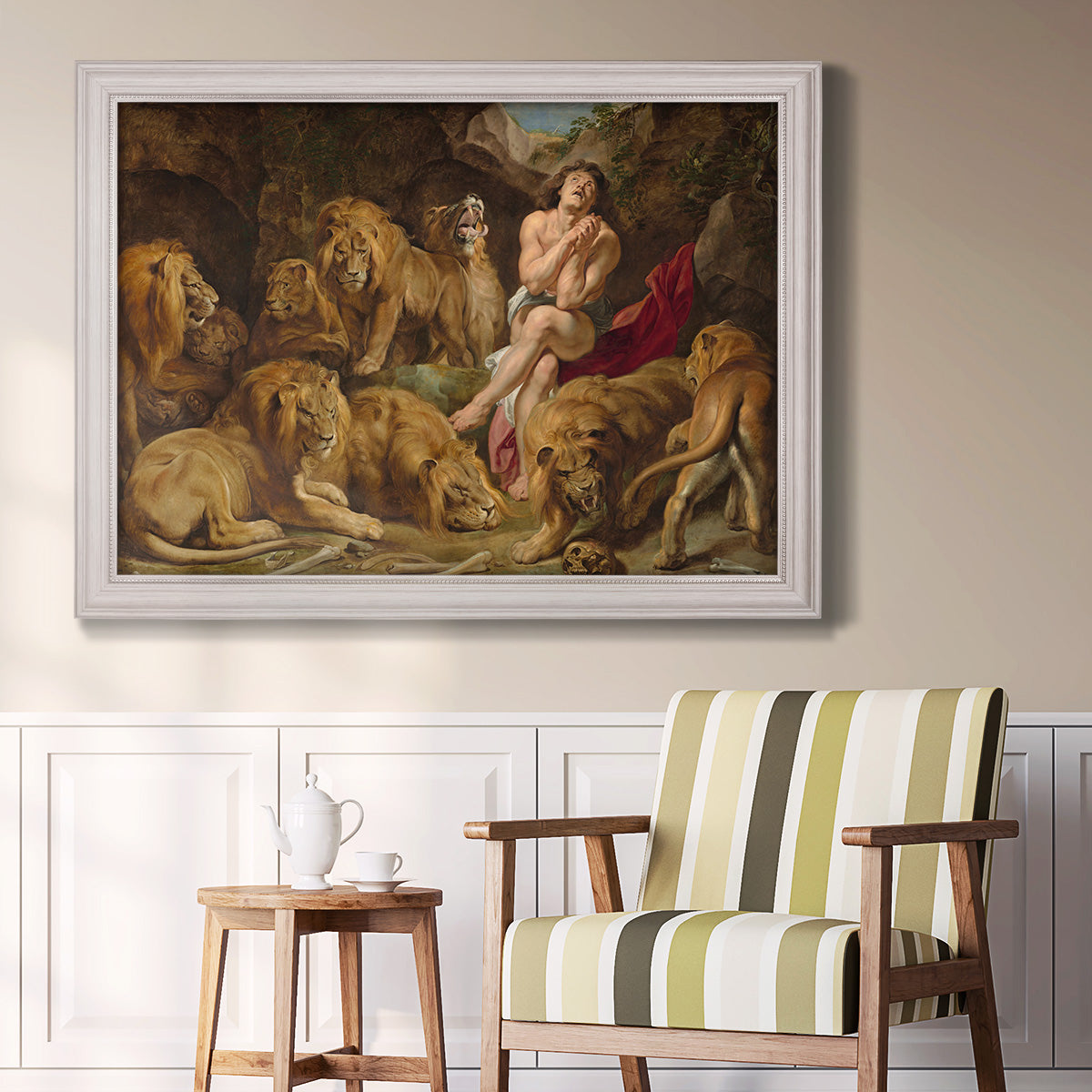 Dramatic biblical painting of Daniel with lions by Peter Paul Rubens in an ornate weathered white frame displayed in a light-toned interior setting.