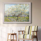 Impressionist white-blossomed orchard landscape by Vincent van Gogh in an ornate weathered white frame displayed in a light-toned interior setting.