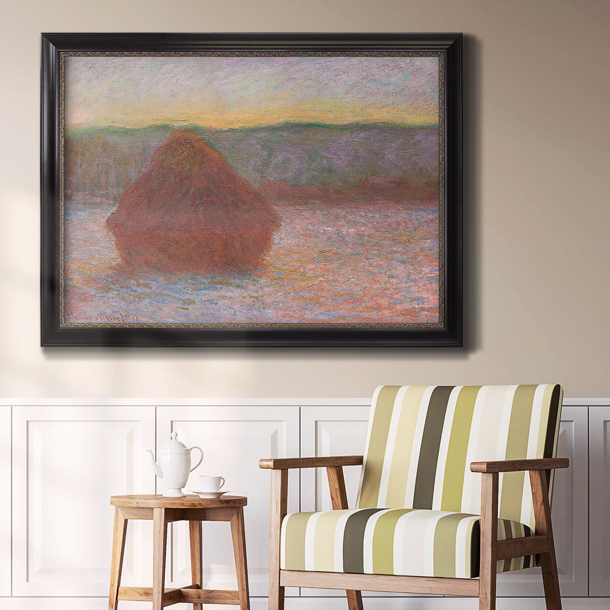 Impressionist haystack sunset scene in winter by Claude Monet in an ornate black frame with gilded inner detail displayed in a light-toned interior setting.
