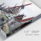 Close-up view of wrapped canvas corner featuring windmills beside calm water.