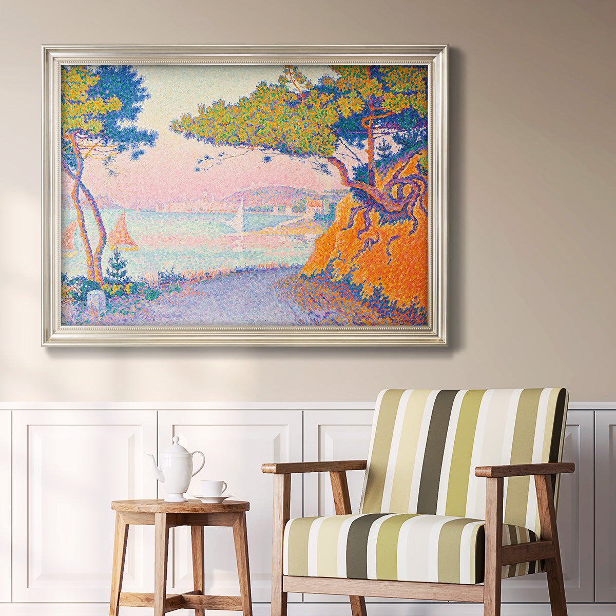 Pointillist coastal seascape by Paul Signac in an ornate champagne frame displayed in a light-toned interior setting.