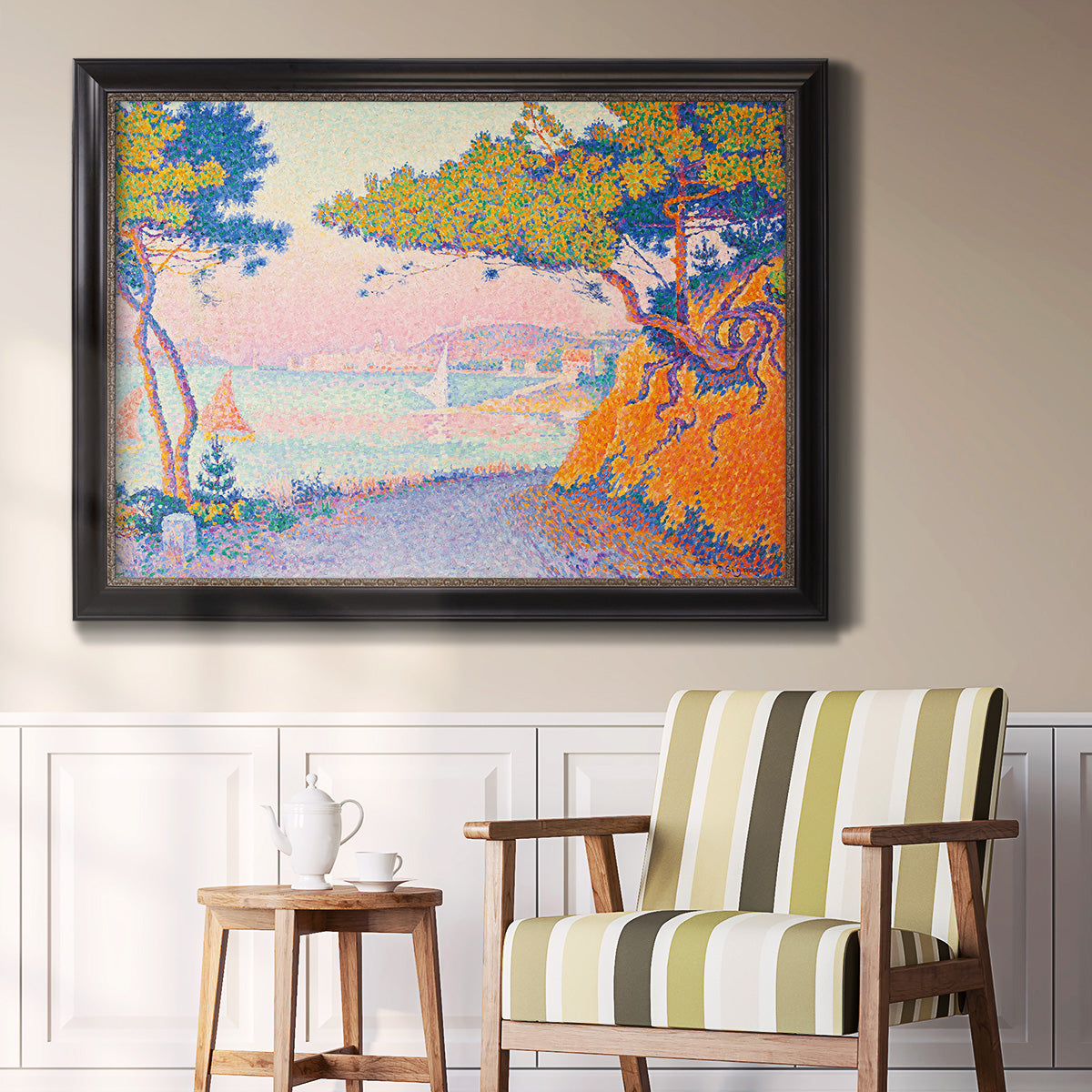 Pointillist coastal seascape by Paul Signac in an ornate black frame with gilded inner detail displayed in a light-toned interior setting.