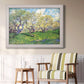 Impressionist spring orchard landscape by Vincent van Gogh in an ornate weathered white frame displayed in a light-toned interior setting.
