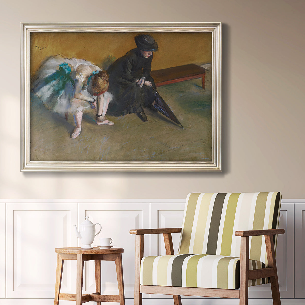Impressionist portrait of a seated woman by Edgar Degas in an ornate champagne frame displayed in a light-toned interior setting.