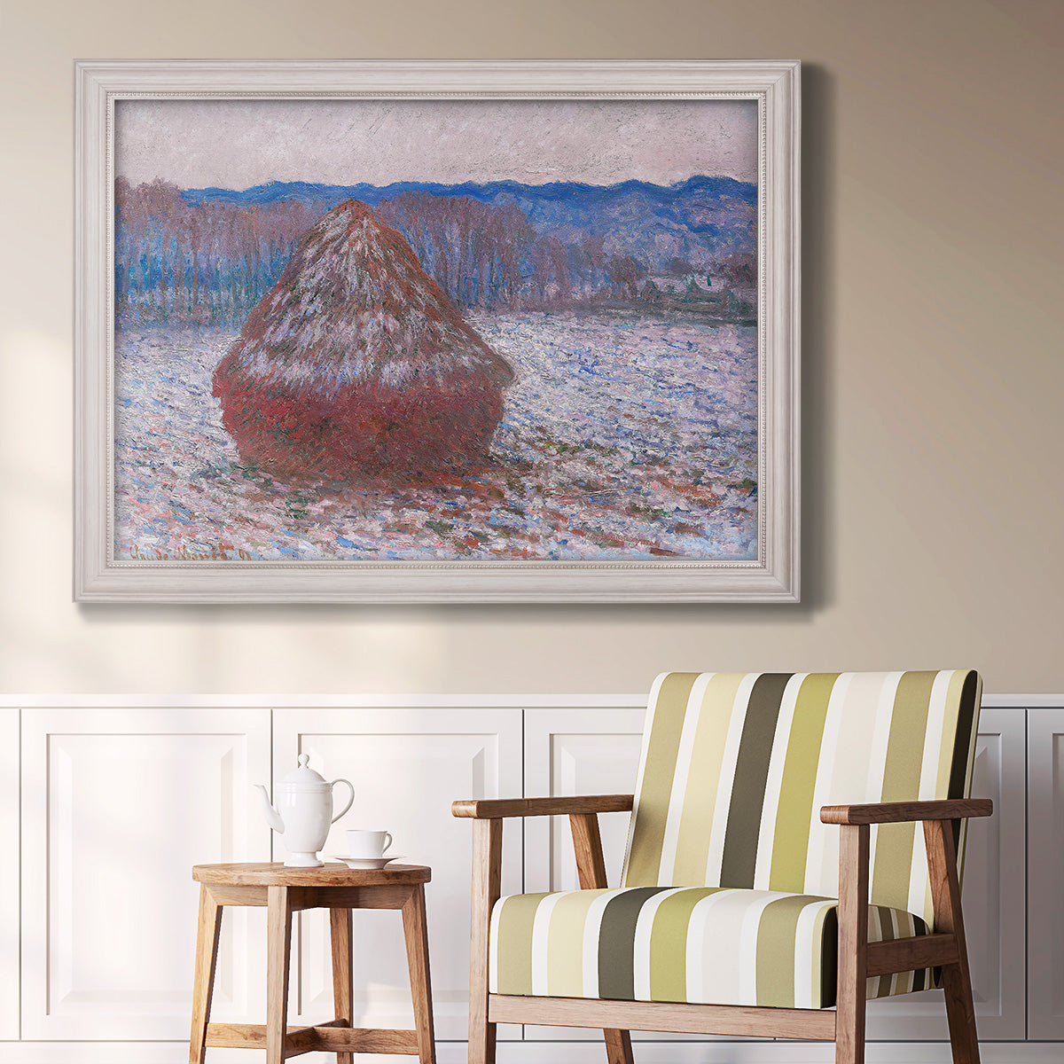 Impressionist single haystack landscape by Claude Monet in an ornate weathered white frame displayed in a light-toned interior setting.