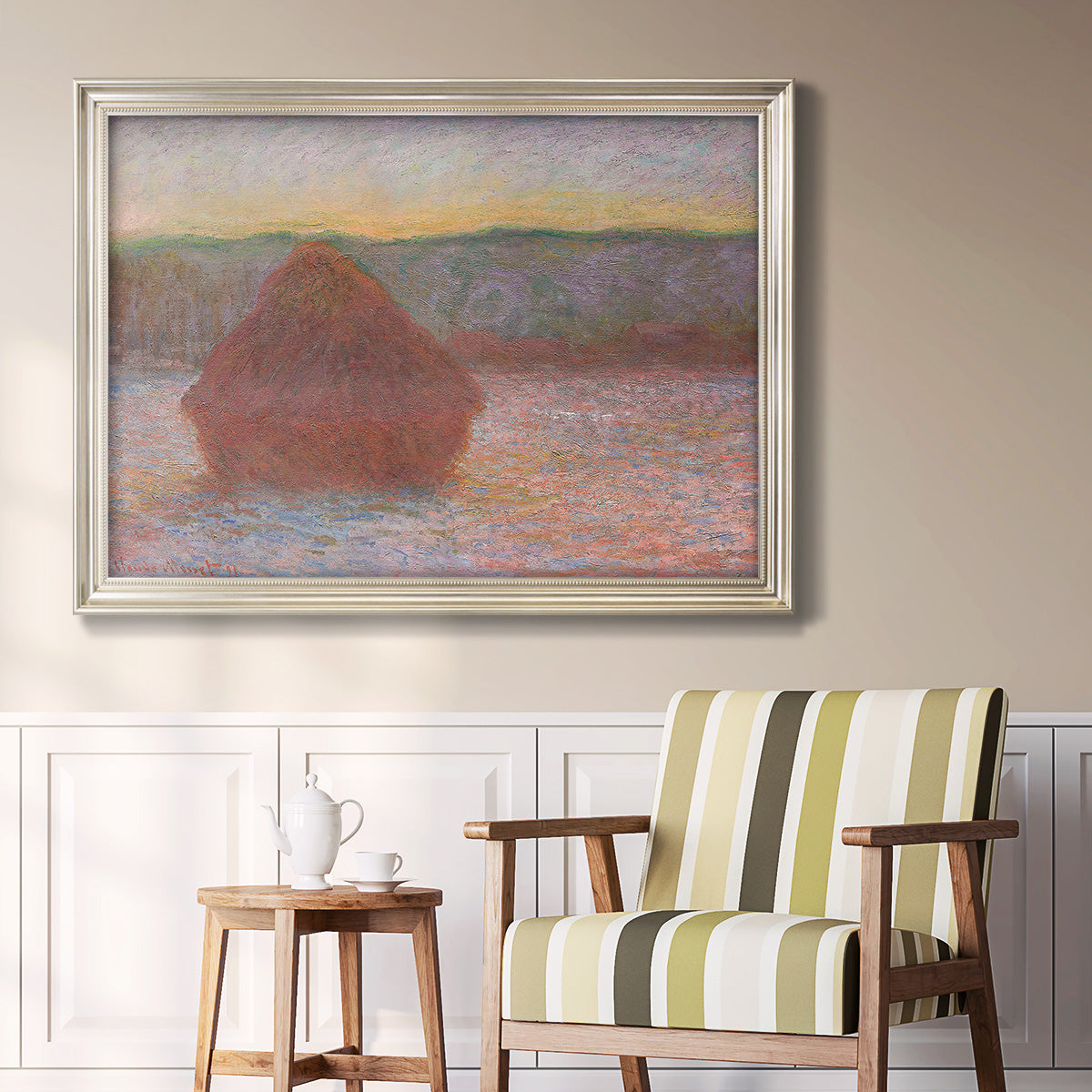 Impressionist haystack sunset scene in winter by Claude Monet in an ornate champagne frame displayed in a light-toned interior setting.