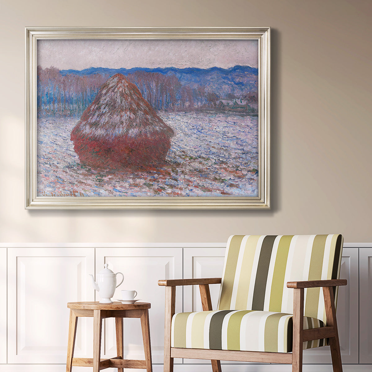 Impressionist single haystack landscape by Claude Monet in an ornate champagne frame displayed in a light-toned interior setting.