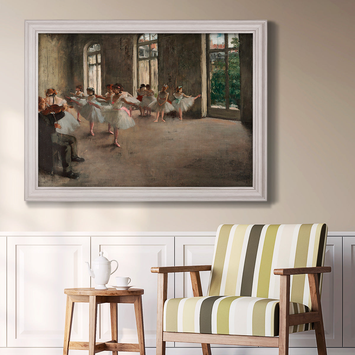 Early impressionist ballet rehearsal painting by Edgar Degas in an ornate weathered white frame displayed in a light-toned interior setting.