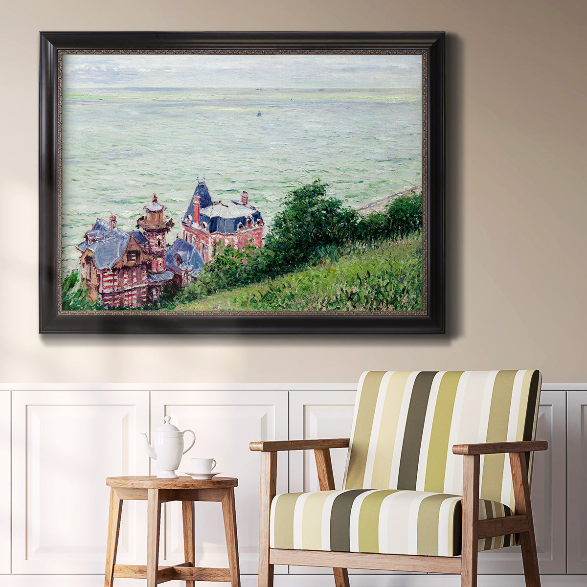 Impressionist coastal villas landscape by Gustave Caillebotte in an ornate black frame with gilded inner detail displayed in a light-toned interior setting.