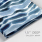 Close-up view of wrapped canvas corner featuring flowing blue watercolor wave forms.