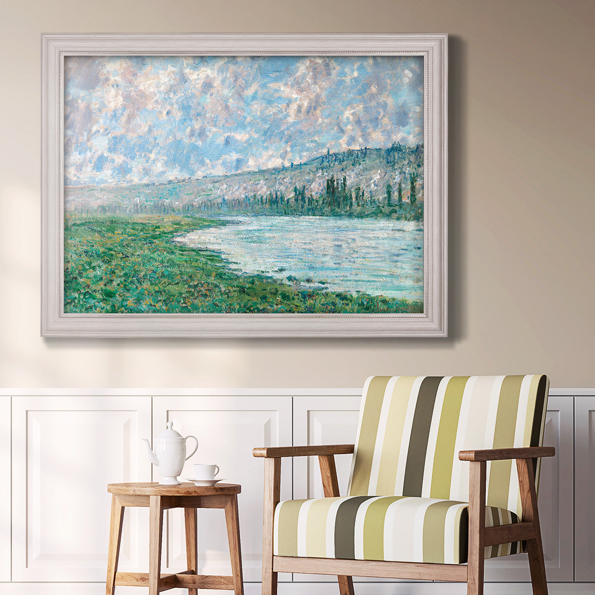 Impressionist river landscape at Vétheuil by Claude Monet in an ornate weathered white frame displayed in a light-toned interior setting.
