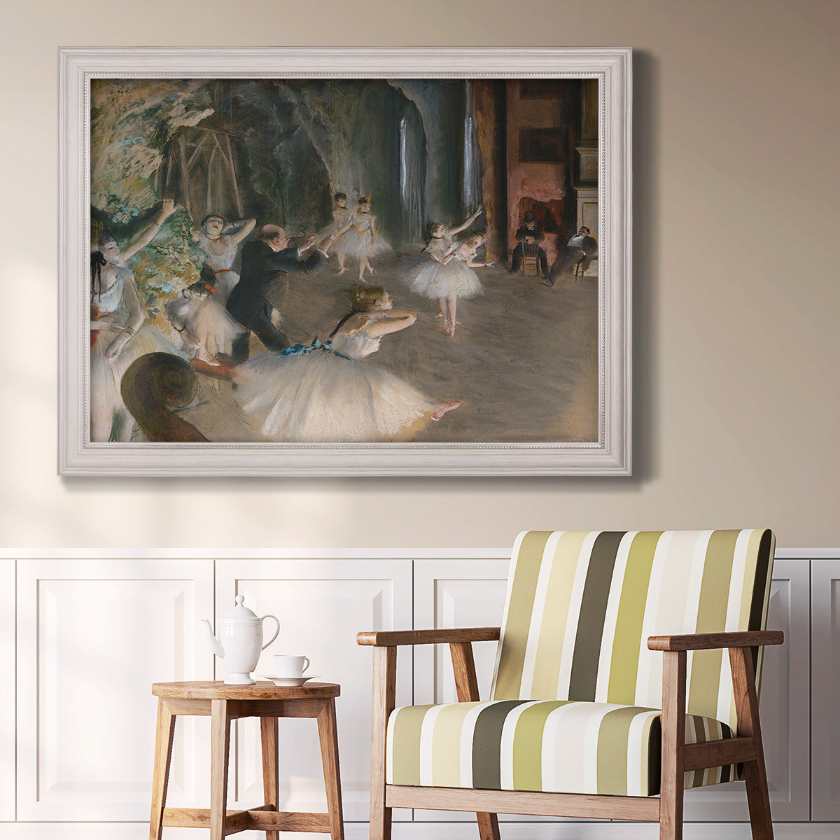 Impressionist backstage ballet scene by Edgar Degas in an ornate weathered white frame displayed in a light-toned interior setting.
