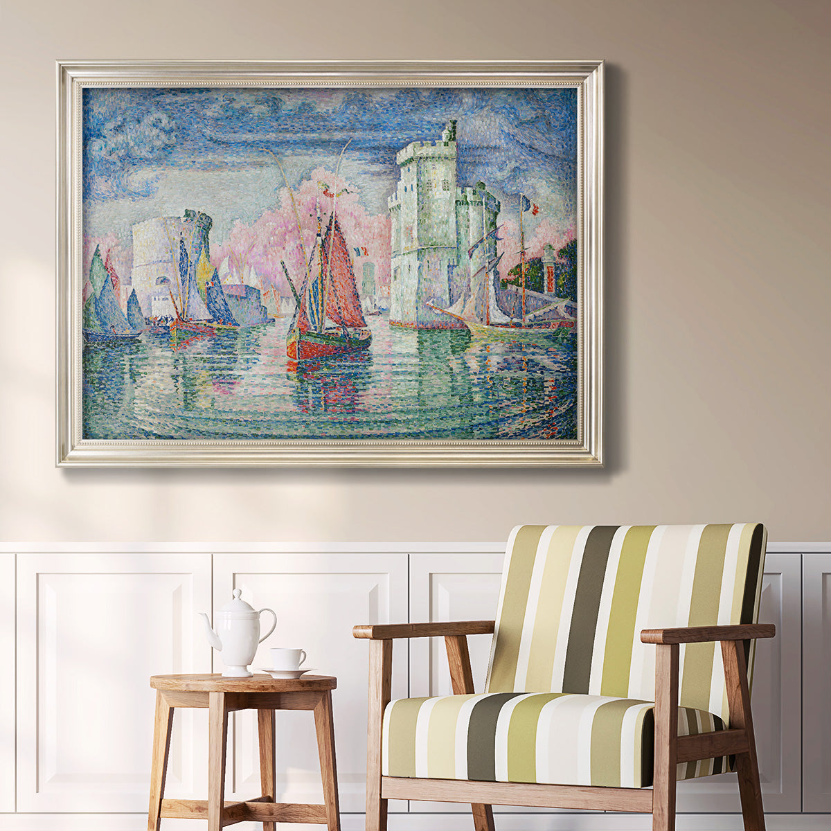 Impressionist harbor scene by Paul Signac in an ornate champagne frame displayed in a light-toned interior setting.