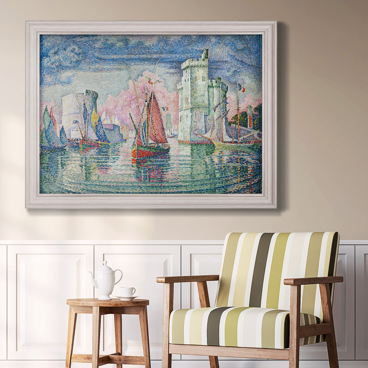 Impressionist harbor scene by Paul Signac in an ornate weathered white frame displayed in a light-toned interior setting.