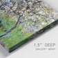 Close-up view of wrapped canvas corner featuring apple trees blooming beside water.