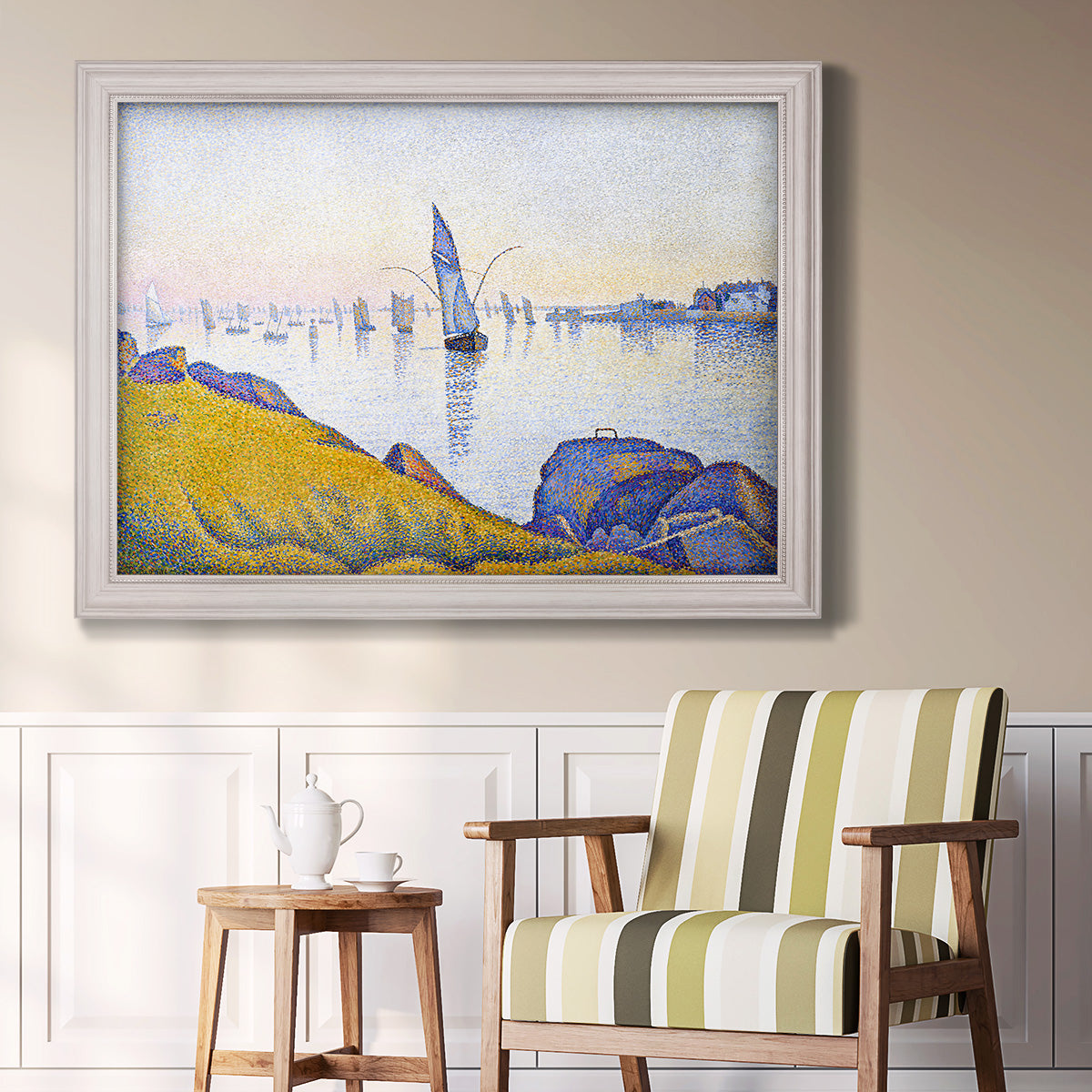 Impressionist coastal harbor at dusk by Paul Signac in an ornate weathered white frame displayed in a light-toned interior setting.