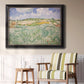 Impressionist countryside landscape near Auvers by Vincent van Gogh in an ornate black frame with gilded inner detail displayed in a light-toned interior setting.