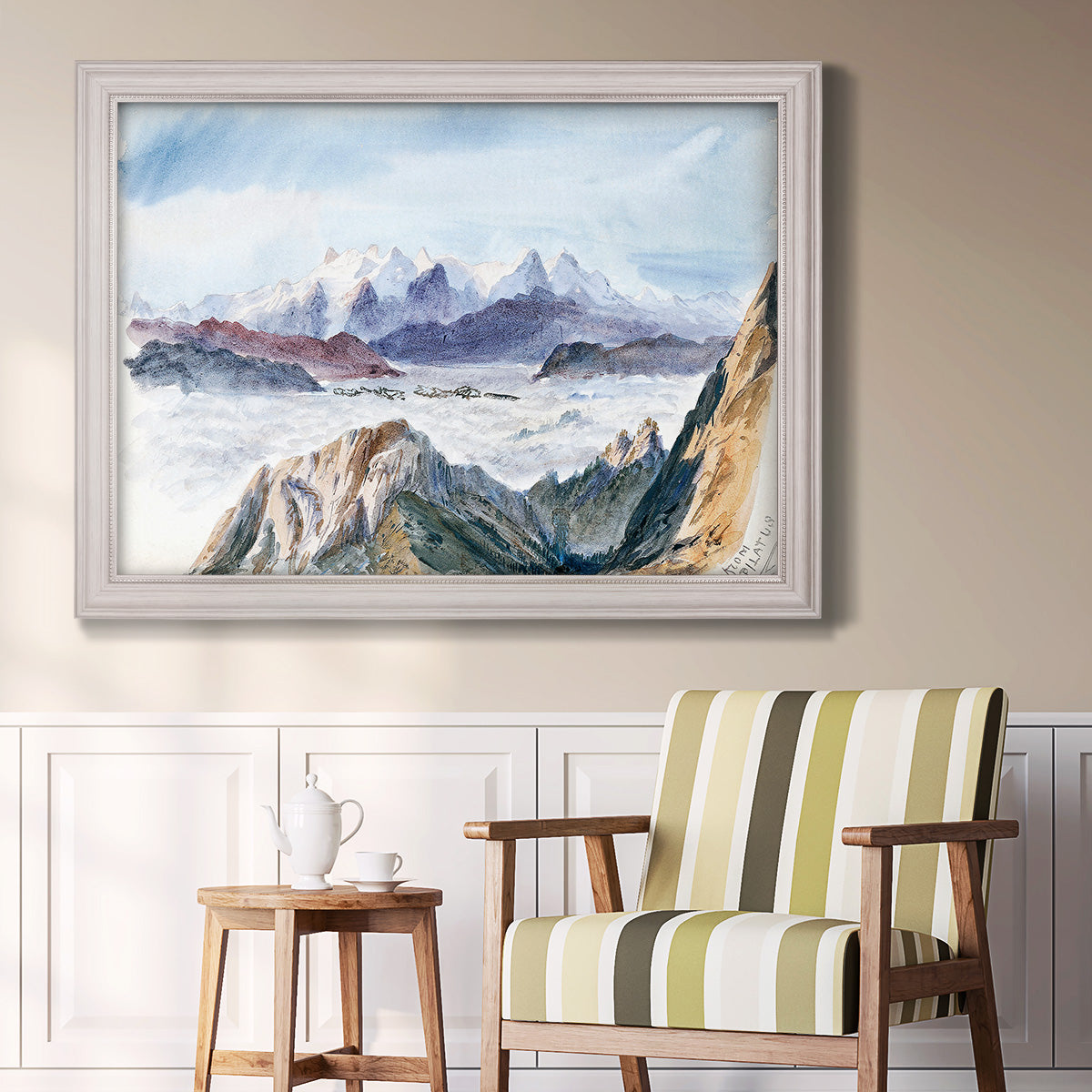 Impressionist alpine mountain landscape by John Singer Sargent in an ornate weathered white frame displayed in a light-toned interior setting.