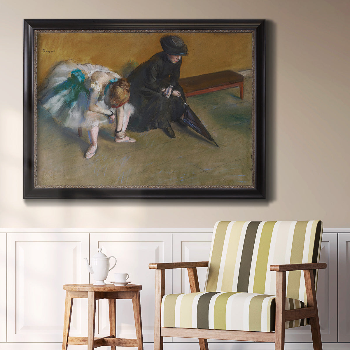 Impressionist portrait of a seated woman by Edgar Degas in an ornate black frame with gilded inner detail displayed in a light-toned interior setting.