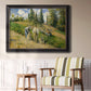 Impressionist countryside harvest scene by Camille Pissarro in an ornate black frame with gilded inner detail displayed in a light-toned interior setting.