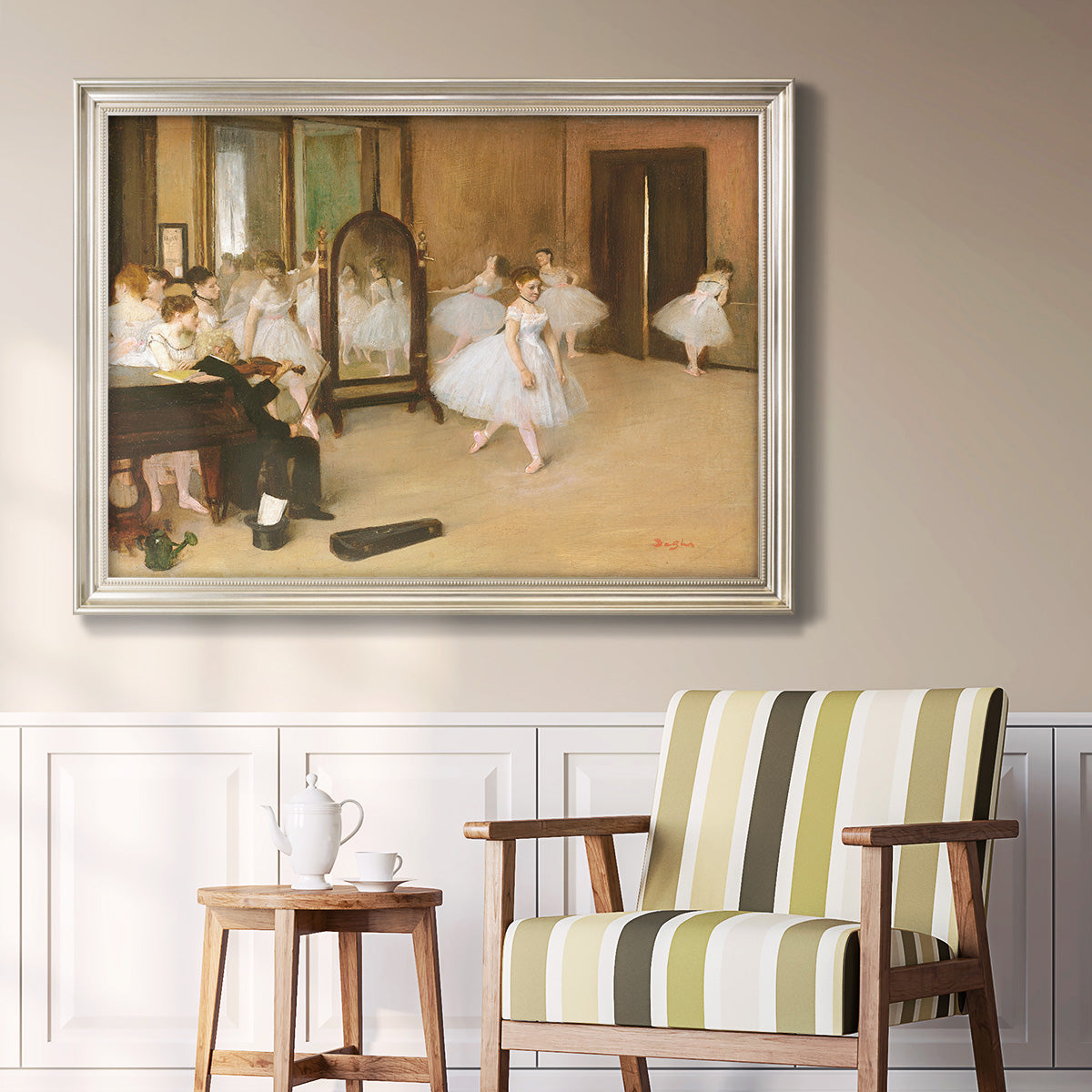 Impressionist dance class interior scene by Edgar Degas in an ornate champagne frame displayed in a light-toned interior setting.