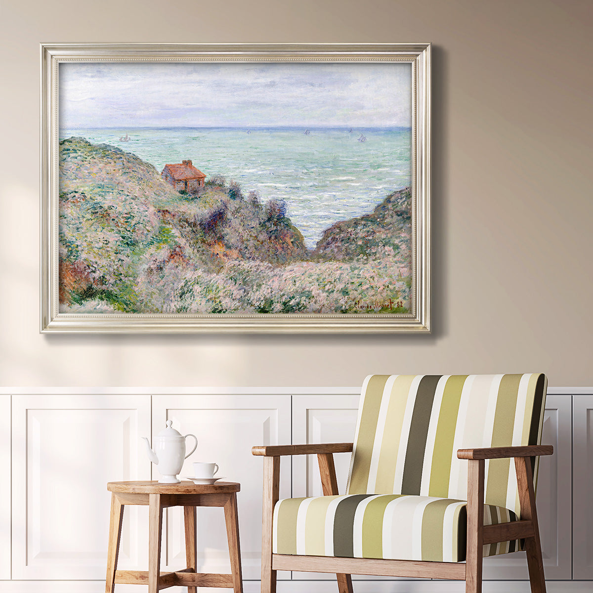 Impressionist coastal watch cabin scene by Claude Monet in an ornate champagne frame displayed in a light-toned interior setting.