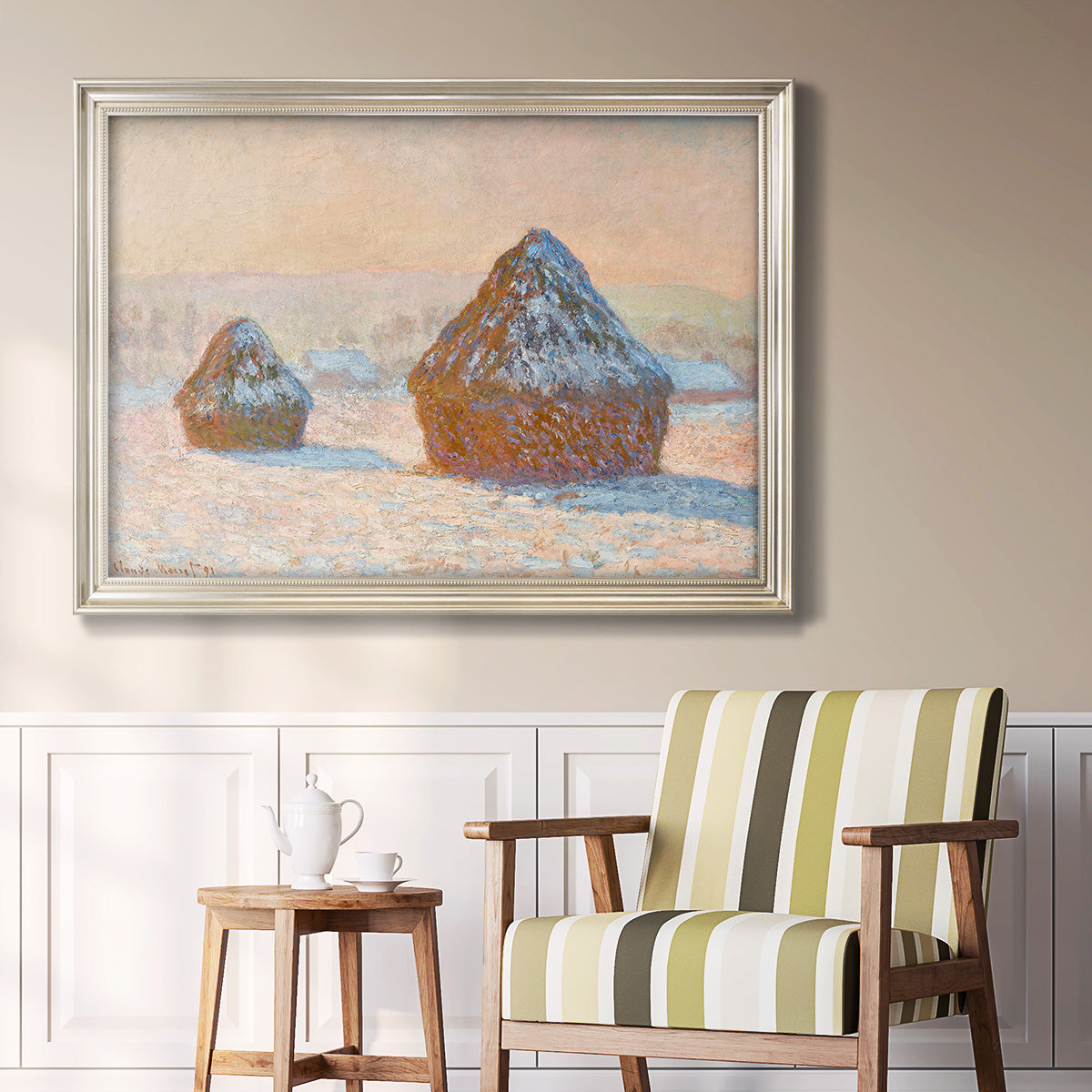Impressionist winter haystack scene by Claude Monet in an ornate champagne frame displayed in a light-toned interior setting.