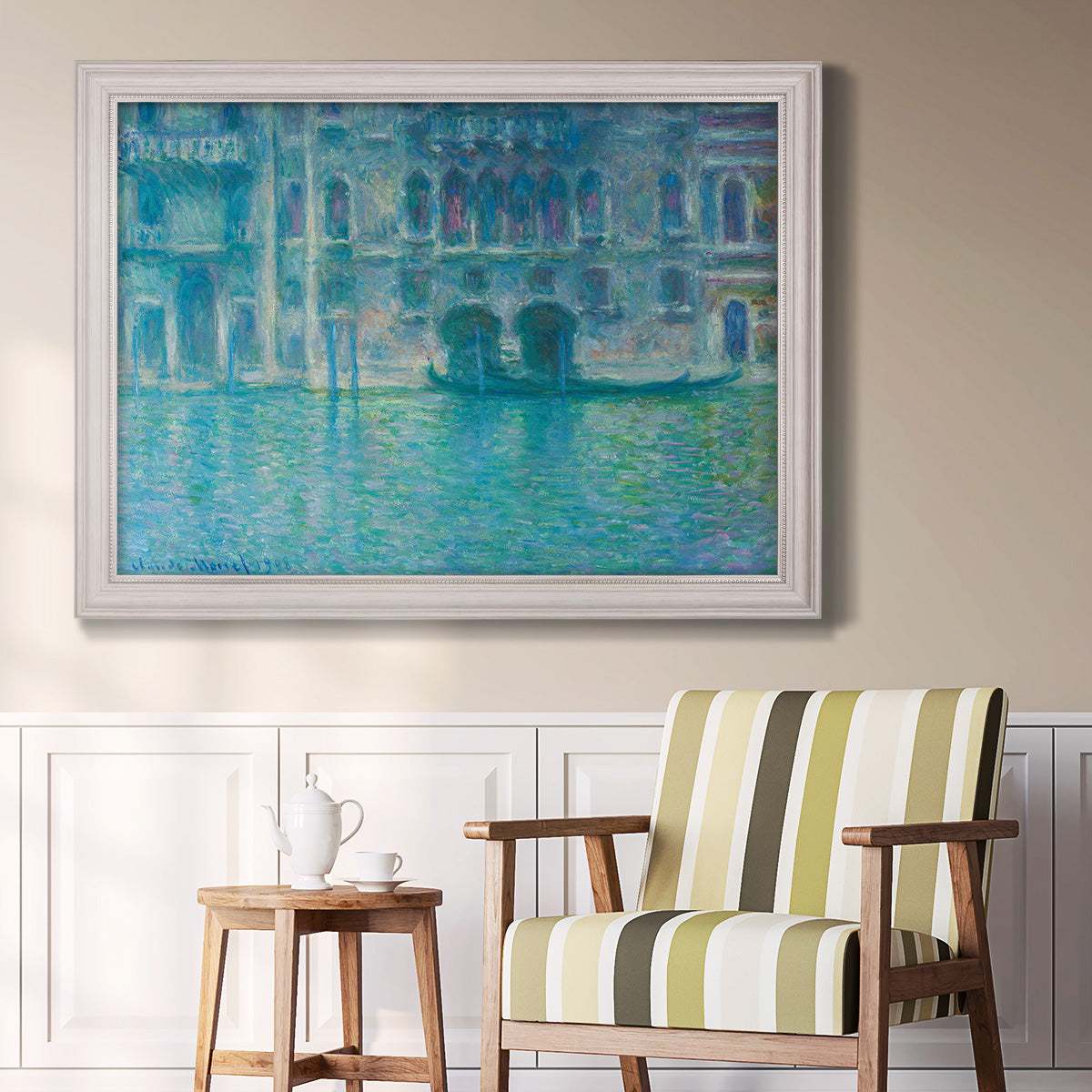Impressionist Venetian palace waterfront scene by Claude Monet in an ornate weathered white frame displayed in a light-toned interior setting.
